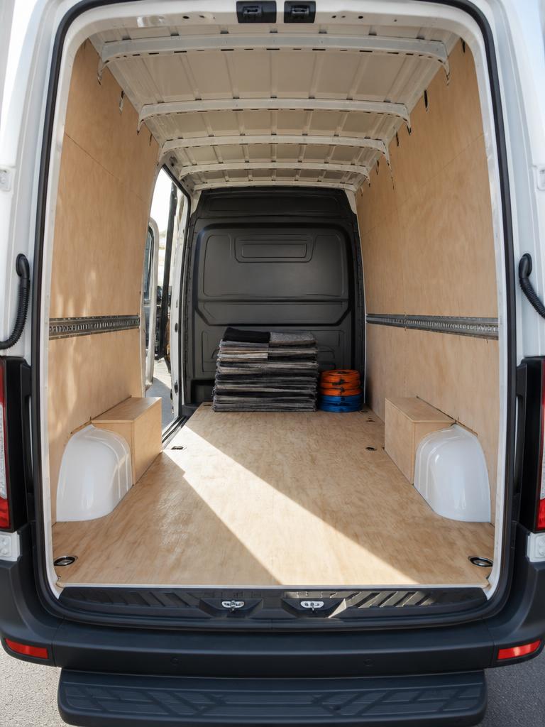 Clean empty interior of a long-wheel-base removals van with folded moving blankets stacked at the front